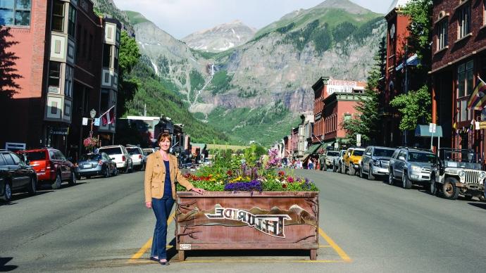 Jonna Wensel '91 stands in front of a sign for Telluride, Colorado.