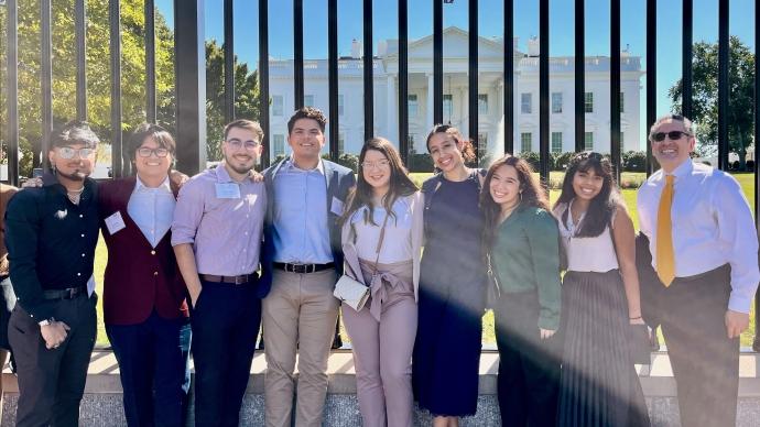 Eight Trinity LOFT students pose in front the White House with Juan Sepulveda