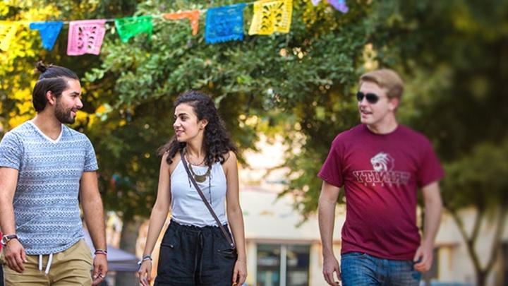 Two trinity students walk together across campus.