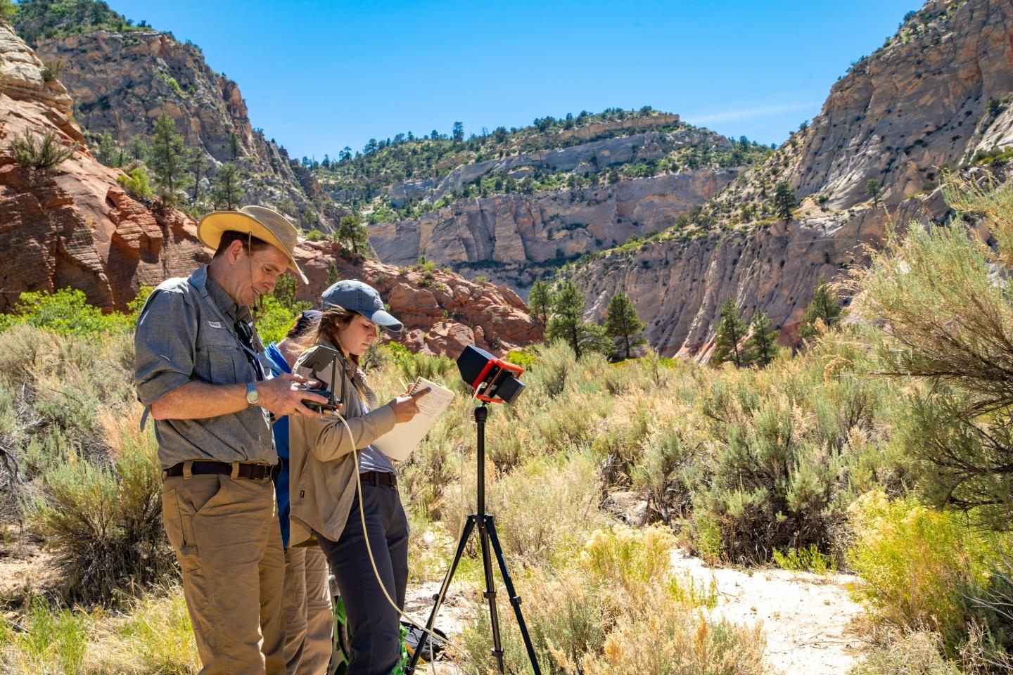 Professor and students taking measurements in canyon