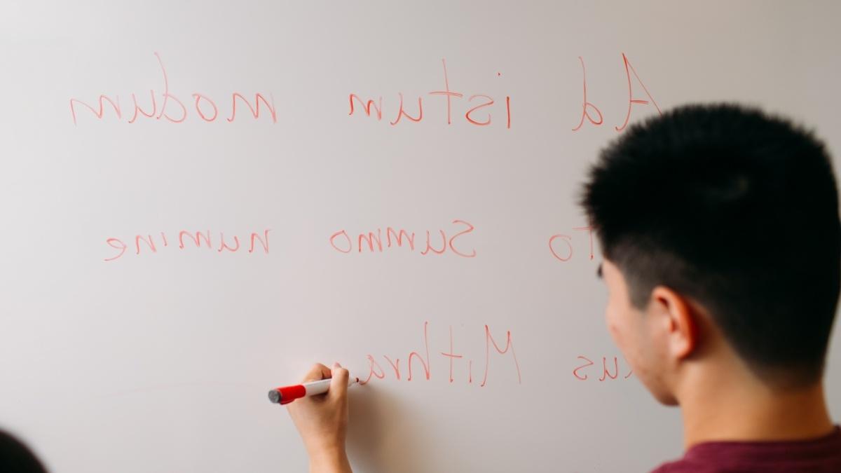 A student writes on a whiteboard